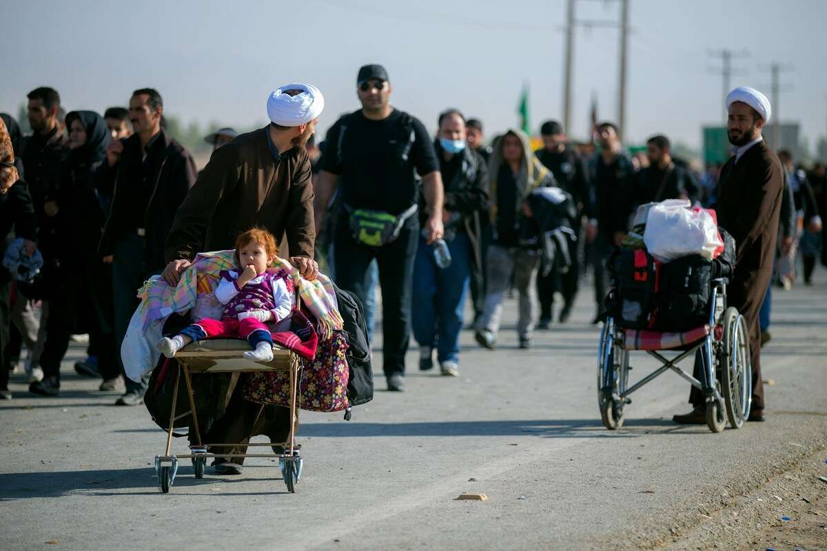 Familias migrantes caminando con niños pequeños en situación de desplazamiento, símbolo de solidaridad y acogida en España y Canarias
